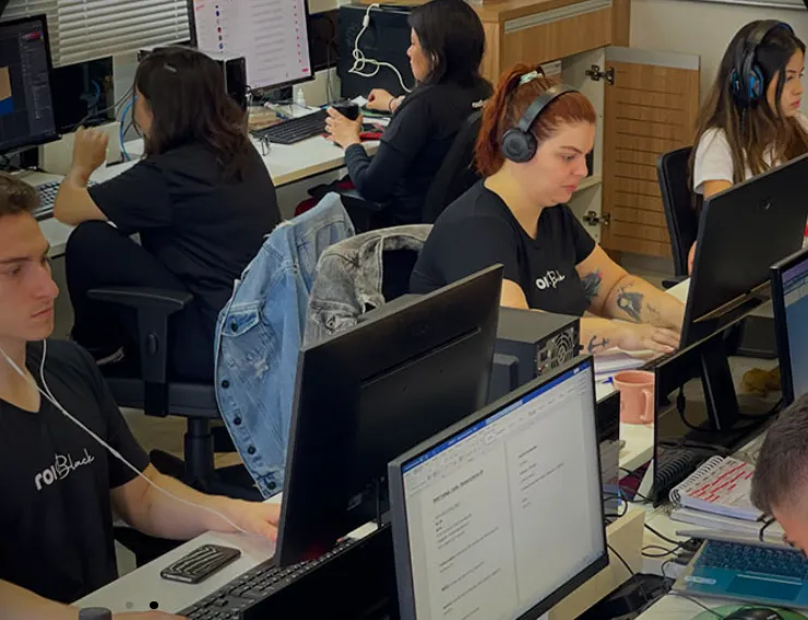 Profissionais da ROI Digital trabalhando em seus computadores no escritório
